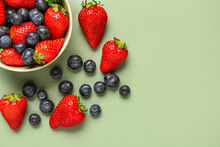 Bowl With Fresh Blueberries And Strawberries On Green Background