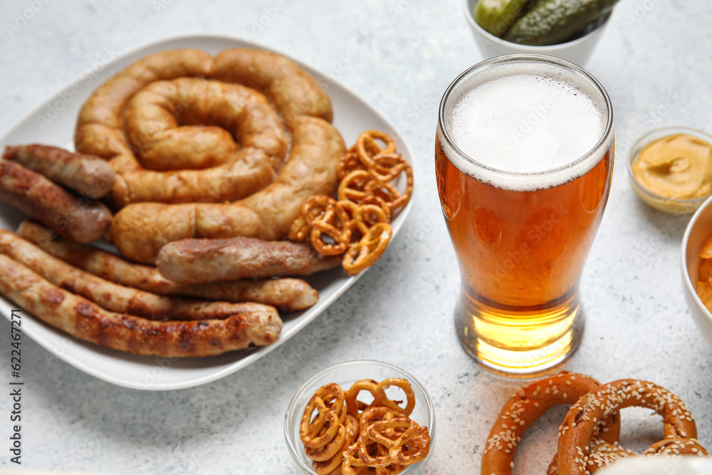 Glass of cold beer and different snacks on light background. Oktoberfest celebration