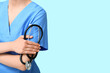 © Pixel-Shot - Female doctor in coat with stethoscope on blue background