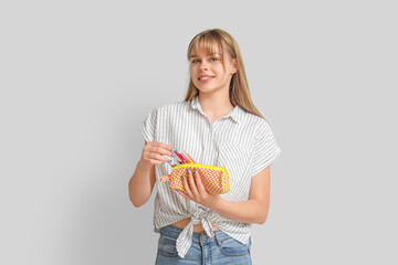 Canvas Print - Female student with pencil case on light background