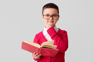 Poster - Little schoolboy with book on grey background