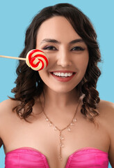 Sticker - Young woman with lollipop on blue background, closeup