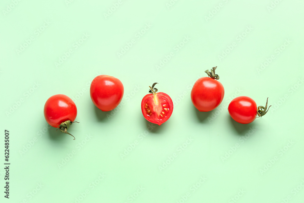 Fresh cherry tomatoes on green background