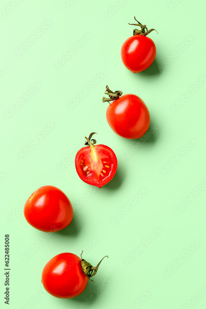 Fresh cherry tomatoes on green background