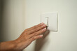 © Chanakon - Earth Hour Close up woman finger turn off or on the light to saving electrical energy. Finger pushing light switch turn on or off. White switch