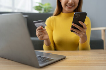 Asian businesswoman shopping online on mobile with credit card for convenient spending at home on vacation, online banking banking, e commerce virtual shopping, secure mobile banking concept.