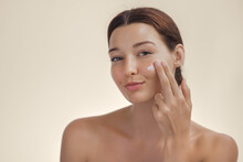 Face Skin Care Concept With Woman Applying Cosmetic Cream On Clean Hydrated Skin
