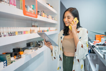 female seller checking the vape mods inside the display table using the digital tablet