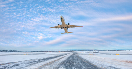 Wall Mural - Commercical white airplane fly up over take-off runway the (ice) snow-covered airport- Norway