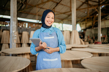 Wall Mural - smiling woman in veil with holding a tablet in wood craft store