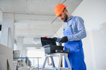 builder on construction site with tool box