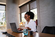 © JustLife - Black businesswoman working on laptop. Portrait of beautiful businesswoman in the office..