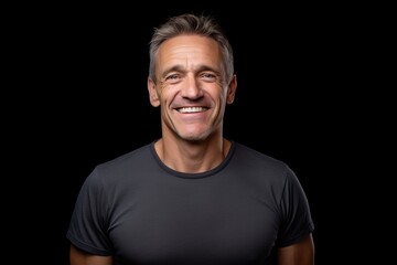 Wall Mural - Portrait of a smiling middle-aged man on a black background
