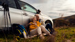 © Zoran Zeremski - Senior couple sitting against the car, resting after hiking in countryside.