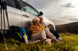 © Zoran Zeremski - Senior couple sitting against the car, resting after hiking in countryside.