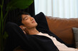 © Prathankarnpap - Calm happy asian man lying on comfortable couch enjoy stress free peaceful mood at home