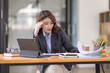 © David - Portrait of tired young business Asian woman work with documents tax laptop computer in office. Sad, unhappy, Worried, Depression, or employee life stress concept