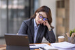 © David - Portrait of tired young business Asian woman work with documents tax laptop computer in office. Sad, unhappy, Worried, Depression, or employee life stress concept