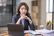 © David - Asian Business woman using calculator and laptop for doing math finance on an office desk, tax, report, accounting, statistics, and analytical research concept
