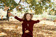 Little caucasian girl with arms outstretched in autumn season
