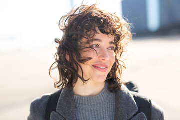 Wall Mural - Pretty young woman in warm coat looking away outside