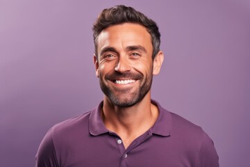 Wall Mural - Portrait of a handsome young man smiling while standing against purple background