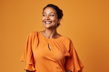 Wall Mural - happy african american woman in orange blouse over yellow background