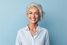 Portrait Of Happy Senior Woman Looking At Camera And Smiling While Standing Against Blue Background