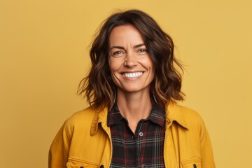 Portrait of a smiling woman looking at camera isolated over yellow background