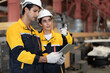 © Nassorn - Latino industrial engineer in white helmet and safety jacket work in heavy metal engineering factory. Technician worker team using tablet computer control metalwork in manufacturing facility, portrait