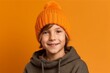 © igolaizola - Portrait of a cute little boy in a knitted hat on a yellow background