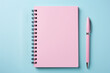 © Caseyjadew - Blank pink notebook and pen flat lay, isolated on blue background