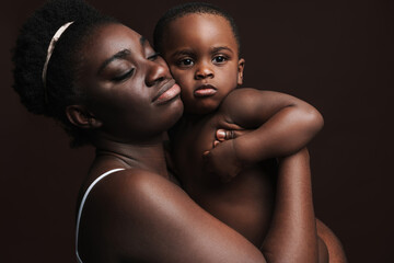 Black young woman hugging and holding her son