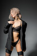 © LIGHTFIELD STUDIOS - fashion-forward and sexy woman in black blazer, panties and lace bra posing on grey background, dyed and wavy ash blonde hair, representation of stylish lingerie on slender body