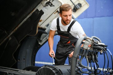 Mechanic repairing the truck in service.