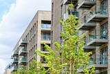 Fototapeta Londyn - London, UK, 11 July 2023: Modern apartment building with balconies and blue sky at Green Street development in London
