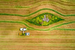 © AmazingAerialAgency - Aerial view of a agricultural machinery at action in a wheat field, kibbutz saar, Israel.