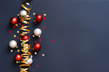 Wall Mural - Christmas card banner with round balls toys, Christmas tree branches and golden decorative ribbon, glitter stars and bokeh lights. Mockup for your congratulations. Blue background.