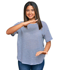 Sticker - Young latin girl wearing casual clothes gesturing with hands showing big and large size sign, measure symbol. smiling looking at the camera. measuring concept.