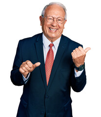 Canvas Print - Senior man with grey hair wearing business suit and glasses pointing to the back behind with hand and thumbs up, smiling confident