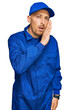 © Krakenimages.com - Bald man with beard wearing builder jumpsuit uniform hand on mouth telling secret rumor, whispering malicious talk conversation