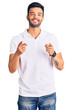© Krakenimages.com - Young handsome hispanic man wearing casual clothes pointing fingers to camera with happy and funny face. good energy and vibes.