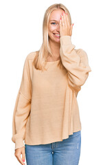 Sticker - Young blonde girl wearing casual clothes covering one eye with hand, confident smile on face and surprise emotion.