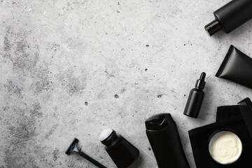Wall Mural - flat lay composition with men's cosmetic products in black packaging on stone background.