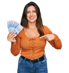 Sticker - Beautiful hispanic woman holding 1000 south korean won banknotes pointing finger to one self smiling happy and proud