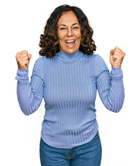 Canvas Print - Middle age hispanic woman wearing casual clothes screaming proud, celebrating victory and success very excited with raised arms