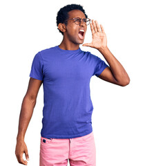 Wall Mural - African handsome man wearing casual clothes and glasses shouting and screaming loud to side with hand on mouth. communication concept.