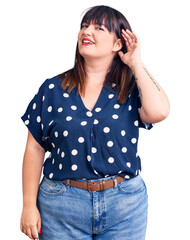 Sticker - Young plus size woman wearing casual clothes smiling with hand over ear listening an hearing to rumor or gossip. deafness concept.