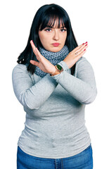 Canvas Print - Young hispanic plus size woman wearing winter scarf rejection expression crossing arms and palms doing negative sign, angry face