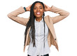 © Krakenimages.com - African american woman wearing business jacket relaxing and stretching, arms and hands behind head and neck smiling happy